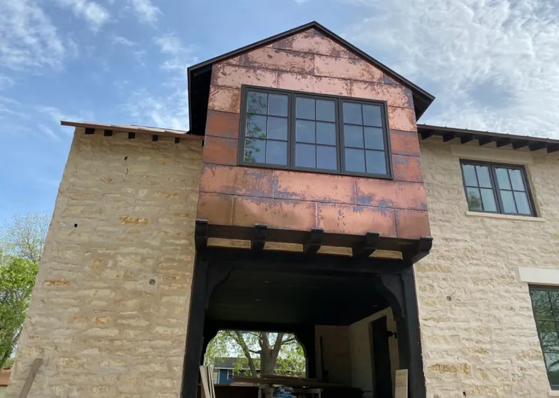 Copper metal panel facade on a stone building for Metal Roof Coating in Firestone