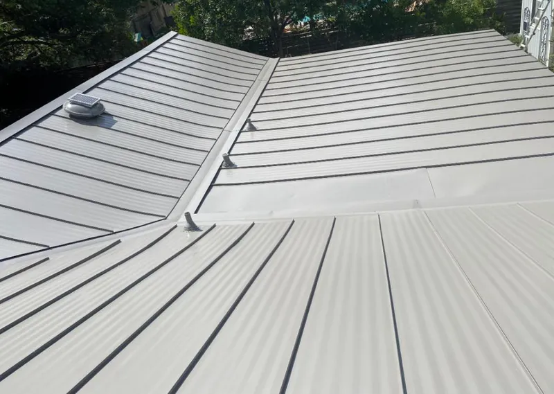 Solar attic fan installed on a metal roof for Roof Ventilation in Firestone